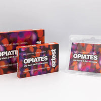 Ez test Opiates -reagenssitestipakkaus, avattu ampulli, mukana tuleva värikartta ja käyttöohjeet valkoisella taustalla.