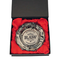 RAW Darkside Crystal -lasituhkakuppi pöydällä, valaistuna, tumma pohja ja kiiltävät leikkaukset heijastamassa valoa.