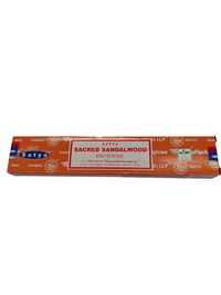Kuva Satya Sandalwood -suitsukepaketista ja sytytetyistä suitsukkeista, joiden lempeä savu leijailee rauhallisessa ympäristössä.